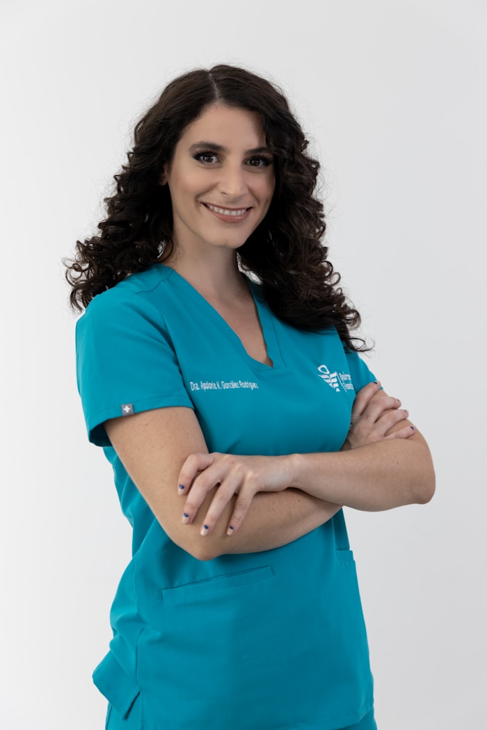 Dr. Elena Marsh smiling in blue scrubs