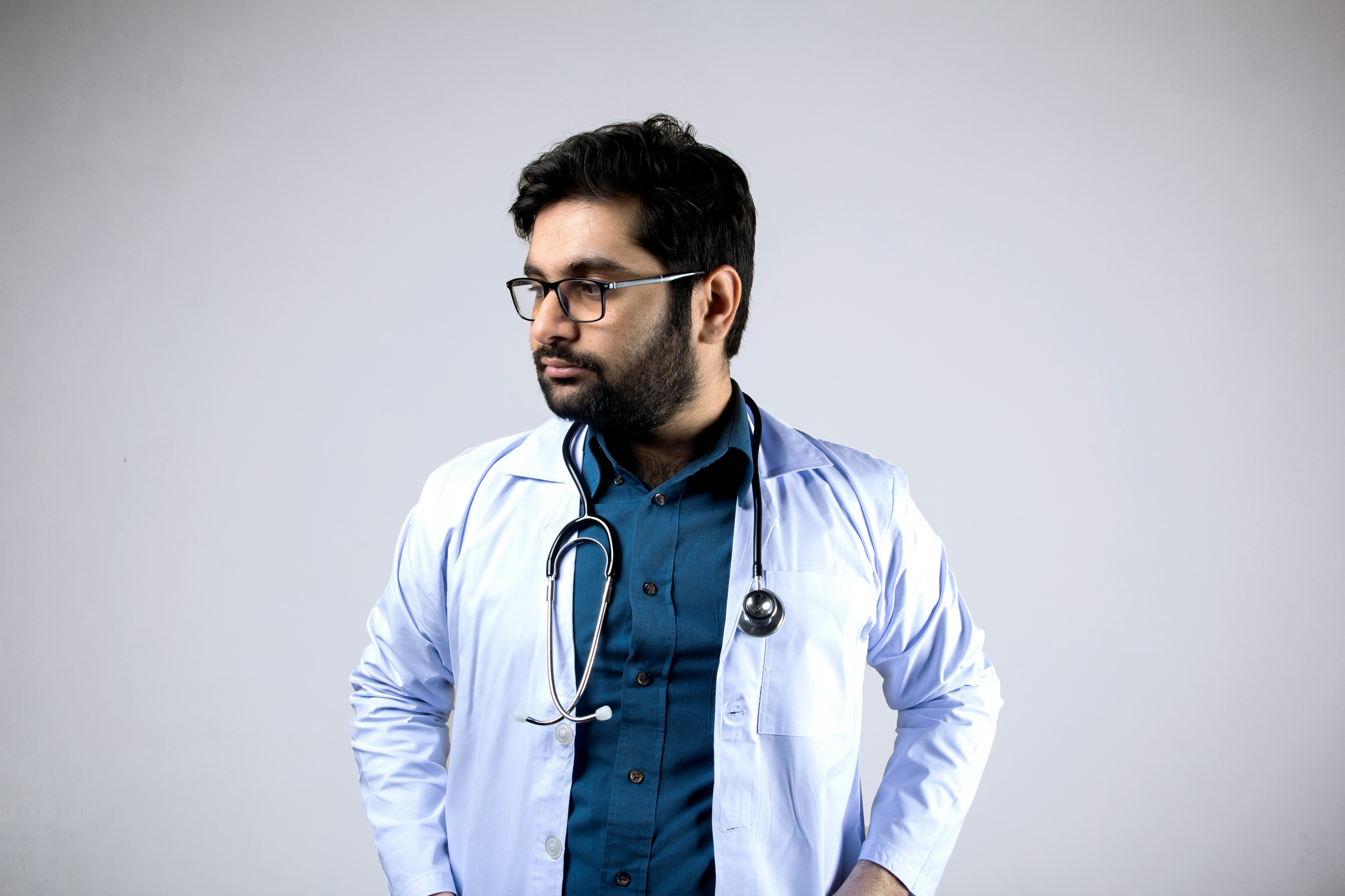 man in white and blue zip up jacket wearing black framed eyeglasses